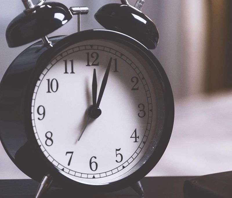 black alarm clock with bells on a desk